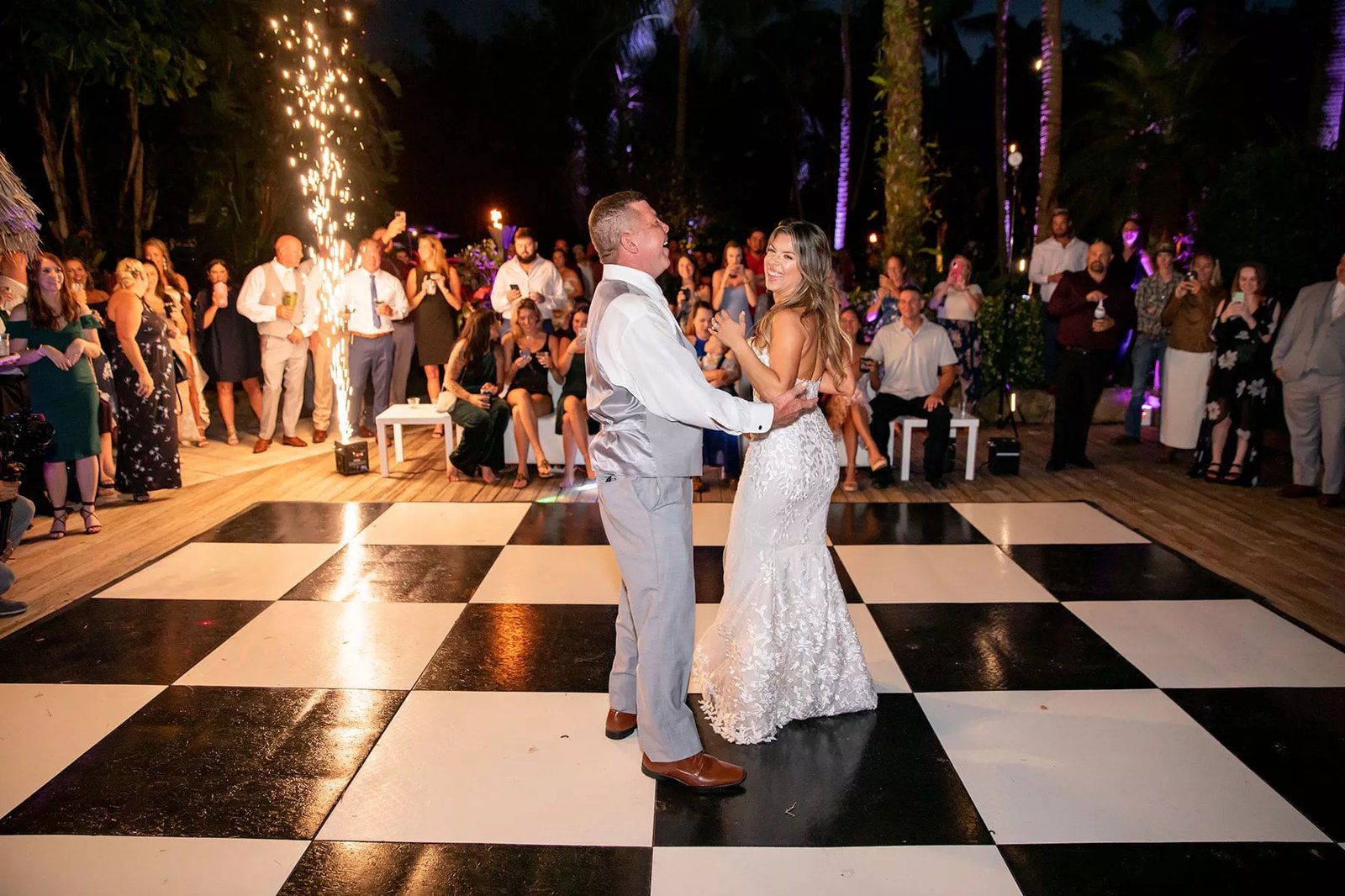 Couple dancing on a checkered floor beneath a chandelier at a Los Angeles ballroom wedding